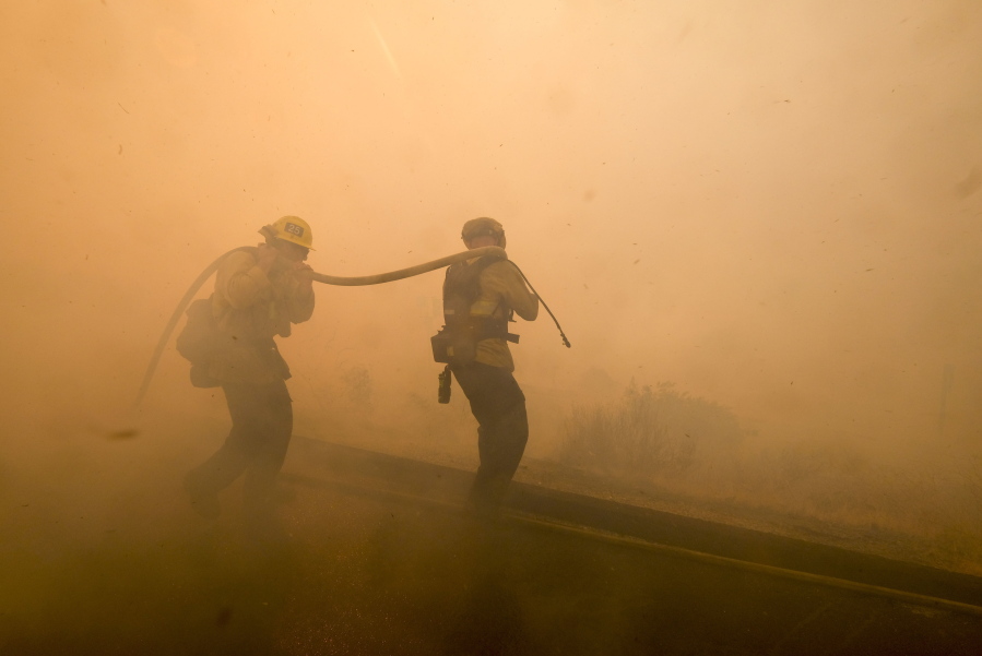 Firefighters battle a fire along the Ronald Reagan (118) Freeway in Simi Valley, Calif., on Monday. (AP Photo/Ringo H.W.
