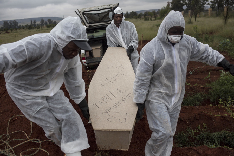 Mortuary workers carry the coffin of an unidentified man for burial at a cemetery outside Johannesburg. At least five bodies of unidentified people are buried on top of each other in each grave.