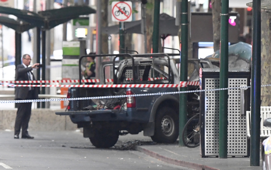 A burnt out vehicle is seen on Bourke Street in Melbourne on Friday. A knife-wielding man stabbed two people, one fatally, in Australia’s second-largest city on Friday in an attack likely linked to terrorism, police said.