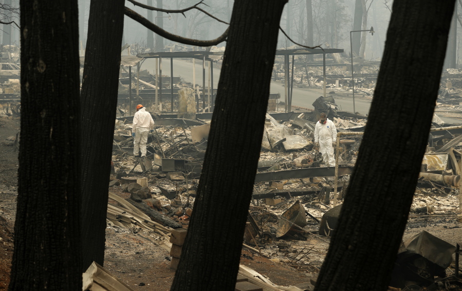 A search and rescue workers search for human remains at a burned out trailer park from the Camp fire Tuesday in Paradise, Calif. The deadliest, most destructive blaze in California history has killed multiple people.