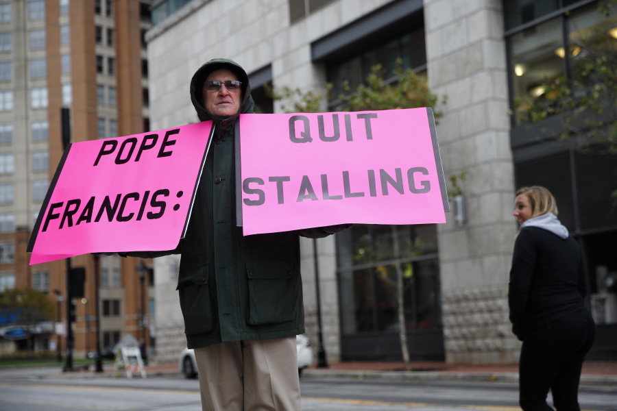 Robert Hoatson, of West Orange, N.J., holds protest signs outside of a hotel hosting the United States Conference of Catholic Bishops’ annual fall meeting, Tuesday, Nov. 13, 2018, in Baltimore.