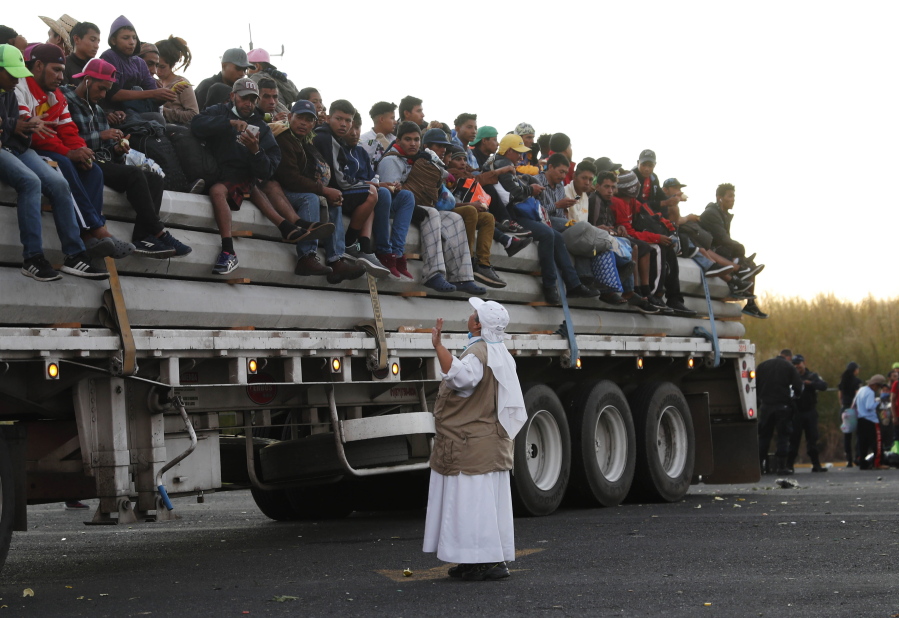 A Catholic nun gives travel advice to Central American migrants riding in the bed of a semi-trailer, as they move toward the U.S. border, in Ixtlán del Rio, Nayarit, Mexico, Tuesday, Nov. 13, 2018. The U.S. government said it was starting work Tuesday to "harden" the border crossing from Tijuana, Mexico, to prepare for the arrival of a migrant caravan leapfrogging its way across western Mexico.