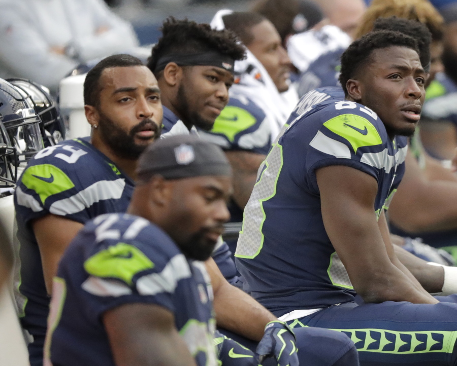 Seattle Seahawks players, including wide receivers David Moore, right, and Doug Baldwin, upper left, sit on the bench late in the second half of an NFL football game against the Los Angeles Chargers, Sunday, Nov. 4, 2018, in Seattle. (AP Photo/Ted S.