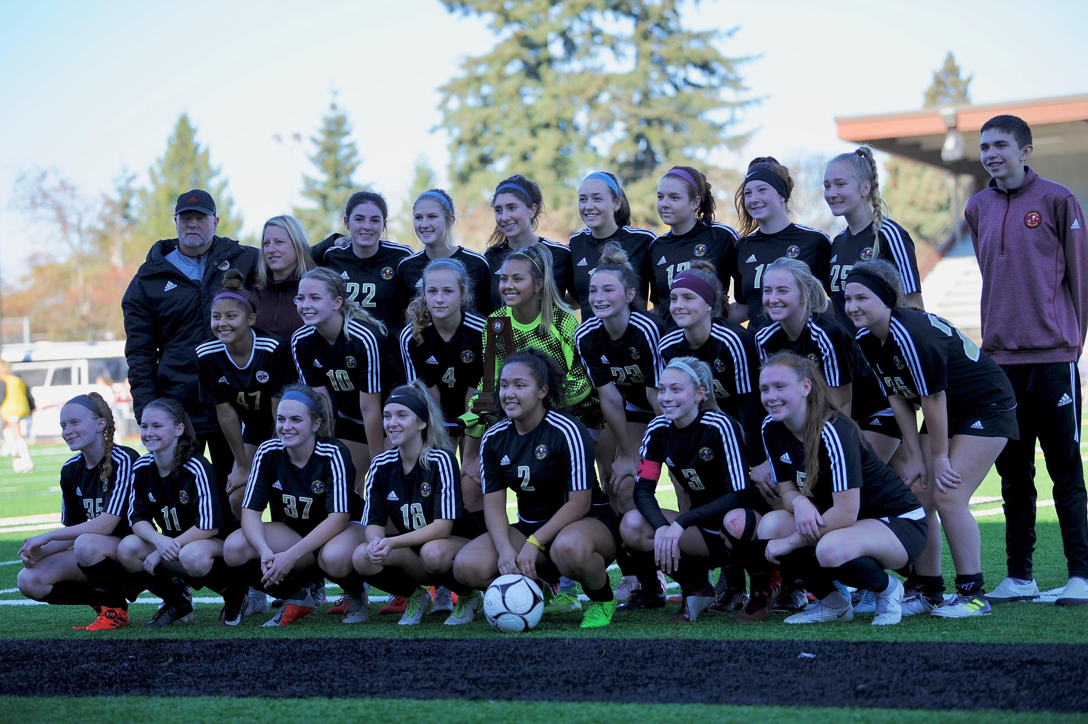 Prairie players pose with the fourth place trophy marking the end of their season after a 3-0 loss at Sparks Stadium in Puyallup on Saturday, Nov. 17, 2018.