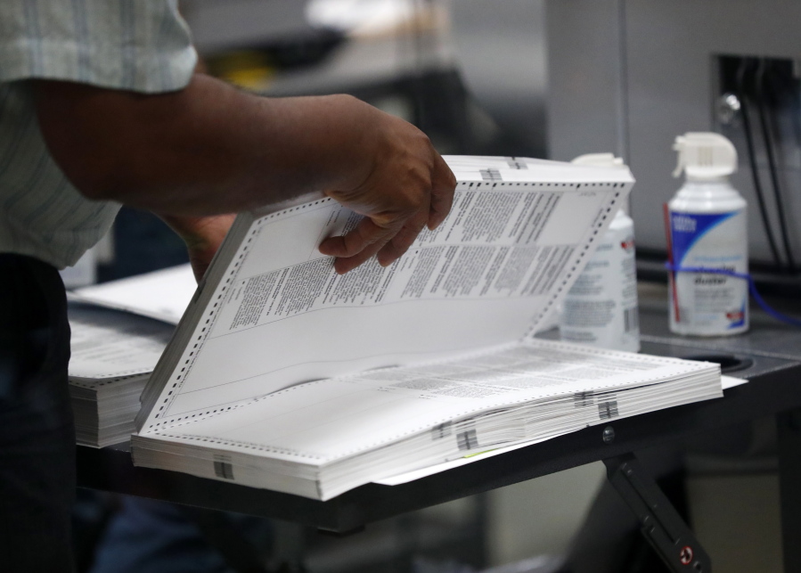 An employee at the Broward County Supervisor of Elections office prepares to load a machine as they count ballots Wednesday in Lauderhill, Fla.