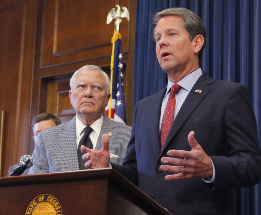 Republican Brian Kemp, right, speaks during a news conference as Georgia Gov. Nathan Deal listens in the Governor’s ceremonial office at the Capitol on Thursday in Atlanta, Ga. Kemp resigned Thursday as Georgia’s secretary of state, a day after his campaign said he’s captured enough votes to become governor despite his rival’s refusal to concede.