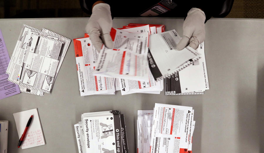 An election worker separates ballots from security envelopes at the King County Elections office Wednesday, Nov. 7, 2018, in Renton. Election workers in King County collected more than 100,000 ballots from drop boxes a day earlier, on Election Day, and over 50,000 came in the mail Wednesday.