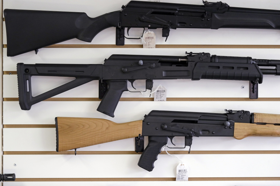 Semi-automatic rifles are displayed on a wall at a gun shop in Lynnwood. I-1639 toughened background checks for people buying semi-automatic rifles, increased the age limit to 21 for buyers of those guns and require secured firearm storage.