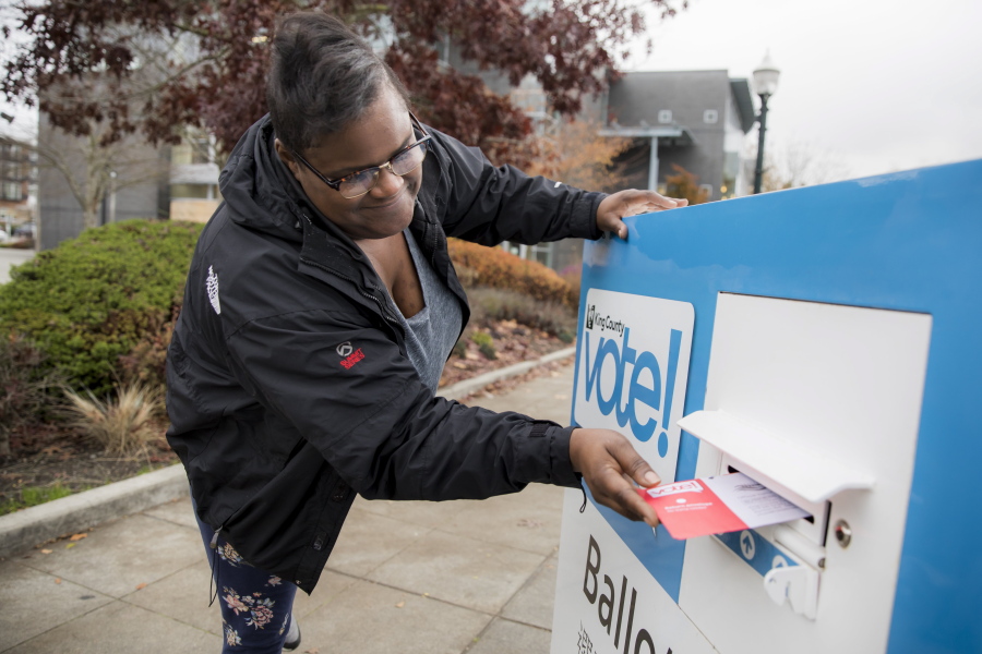 Sherita Cooks drops her ballot in a King County Elections ballot drop box on Election Day for the midterms Tuesday Nov. 6, 2018, in Burien, Wash.