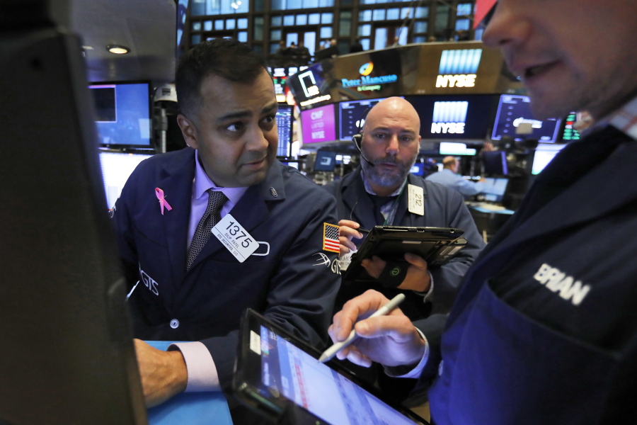 FILE- In this Thursday, Nov. 8, 2018, file photo, specialist Dilip Patel, left, works at his post on the floor of the New York Stock Exchange. The U.S. stock market opens at 9:30 a.m. EDT on Thursday, Nov. 15.