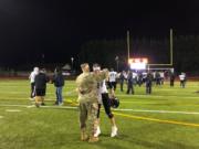 Tyler Flanagan (21) is embraced after Woodland's season-ending 58-38 loss at Tumwater.