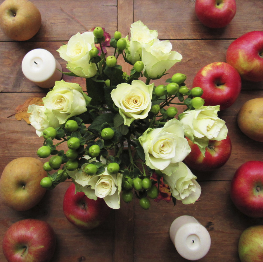 This November 2015 photo provided by Katie Workman shows flowers and apples on a table in New York. Setting up as much as possible ahead of time - such as flowers and little touches like fresh apples on a table— gives you a real leg up when it comes to getting the meal on the table Thanksgiving Day.
