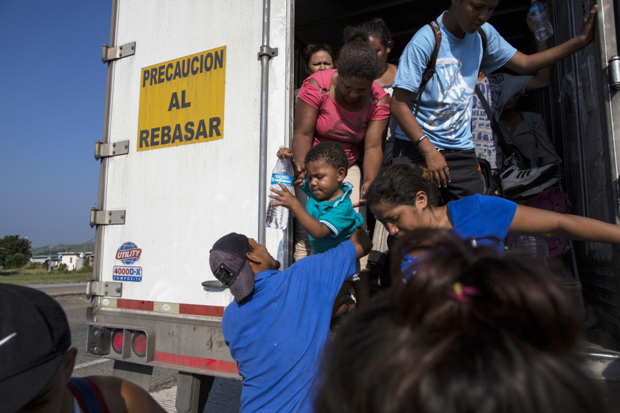 Joel Eduardo Espinar reaches for his son, Eduardo, 2, from his wife, Yamilet, while arriving in Arriaga, Mexico, after a ride on a truck. His plan is to request asylum rather than cross the border illegally. “I’m kind of fearful of what will happen once we get to the U.S. border,” he said. Regardless, he says, they will not go back to Honduras.