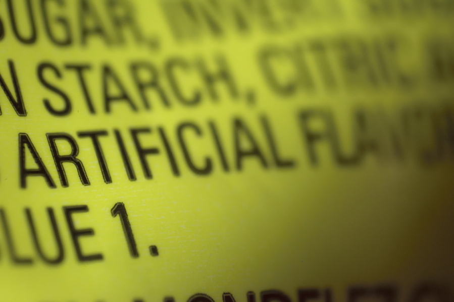 This Thursday, Nov. 8, 2018 photo shows part of an ingredient label, which lists “artificial flavoring,” on a packet of candy in New York. In November 2018, the U.S. Food and Drug Administration has decided to give companies two years to purge their products of the six ingredients, described only as “artificial flavors” on packages. The words “artificial flavor” or “natural flavor” refer to any of thousands of ingredients.