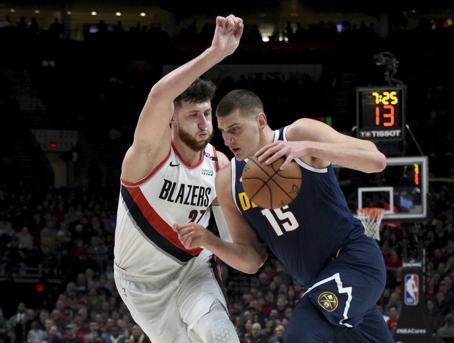 Denver Nuggets center Nikola Jokic, right, drives to the basket on Portland Trail Blazers center Jusuf Nurkic during the first half of an NBA basketball game in Portland, Ore., Friday, Nov. 30, 2018.