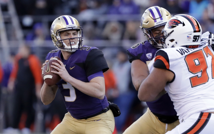 Washington quarterback Jake Browning, left, drops back to pass against Oregon State in the first half of an NCAA college football game Saturday, Nov. 17, 2018, in Seattle.