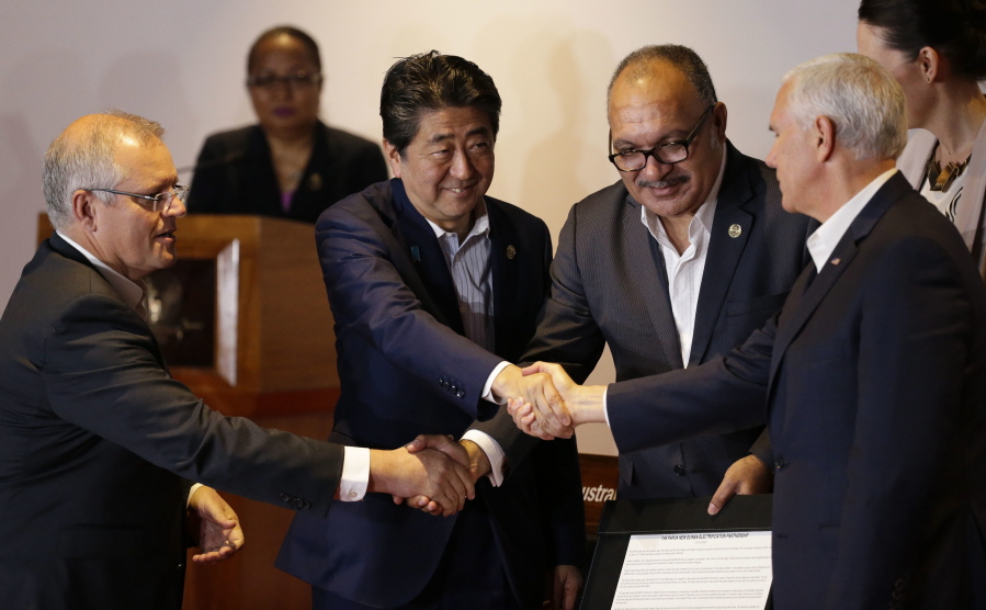 From left, Australian Prime Minister Scott Morrison, Japan Prime Minister Shinzo Abe, Papua New Guinea Prime Minister Peter O’Neill and U.S. Vice President Mike Pence shake hands during the Leaders Electrification Project meeting as part of the APEC 2018 at Port Moresby, Papua New Guinea, on Sunday. In a statement issued to media, Papua New Guinea has invited Australia, Japan, New Zealand and the United States to work together to support its enhanced connectivity and the goal of connecting 70% of its population to electricity by 2030. Currently only about 13% of Papua New Guinea’s population have reliable access to electricity.