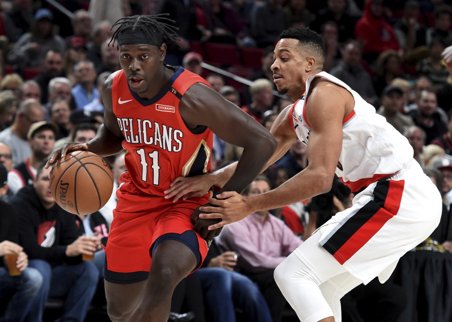 New Orleans Pelicans guard Jrue Holiday, left, drives to the basket on Portland Trail Blazers guard CJ McCollum during the first half of an NBA basketball game in Portland, Ore., Thursday, Nov. 1, 2018.