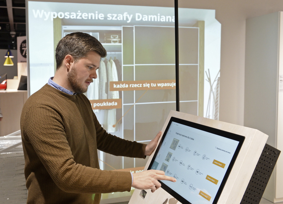 In this Thursday Nov. 22, 2018 photo, Andreas Flygare, the project manager for the new Warsaw Ikea store presents a system projecting furniture interior a wall, in Warsaw, Poland. The new Ikea store, recently opened in a city shopping mall, is part of a global strategy by the Swedish furniture chain to adapt to a changing consumer environment by opening small, accessible stores in city centers to complement the traditional large out-of-town store stores.