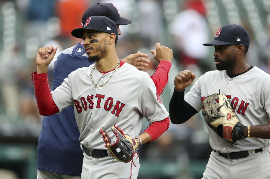Boston Red Sox right fielder Mookie Betts, front left, and center fielder Jackie Bradley Jr., right, greet teammates after a win over the Detroit Tigers in a baseball game, Sunday, July 22, 2018, in Detroit.