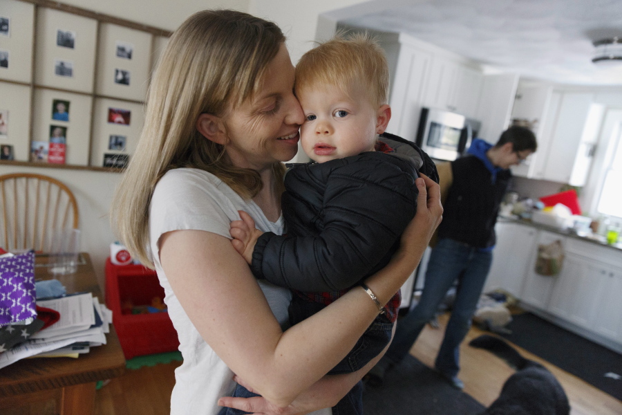 In this Friday, Nov. 16, 2018, photo, Anna Ford hugs her son Eli as he arrives home from nursery school with Ford’s partner, Sara Watson, background, in the village of Saunderstown, in Narragansett, R.I. Three years after the landmark U.S. Supreme Court case that gave same-sex couples the right to marry nationwide, a patchwork of outdated state laws governing who can be a legal parent presents obstacles for many LGBTQ couples who start a family, lawyers say.