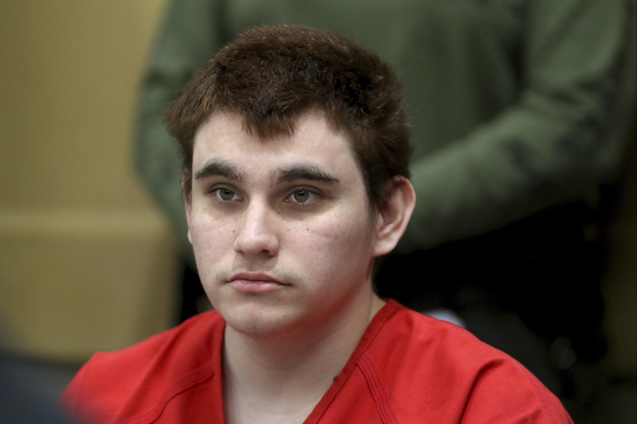Florida school shooting suspect Nikolas Cruz listens during a status check on his case at the Broward County Courthouse in Fort Lauderdale, Fla. Authorities say Cruz attacked a detention officer at the county jail, Tuesday, Nov. 13, and now faces new charges. Cruz is charged with killing 17 people and wounding 17 others in the Feb. 14 mass shooting at Marjory Stoneman Douglas High School.