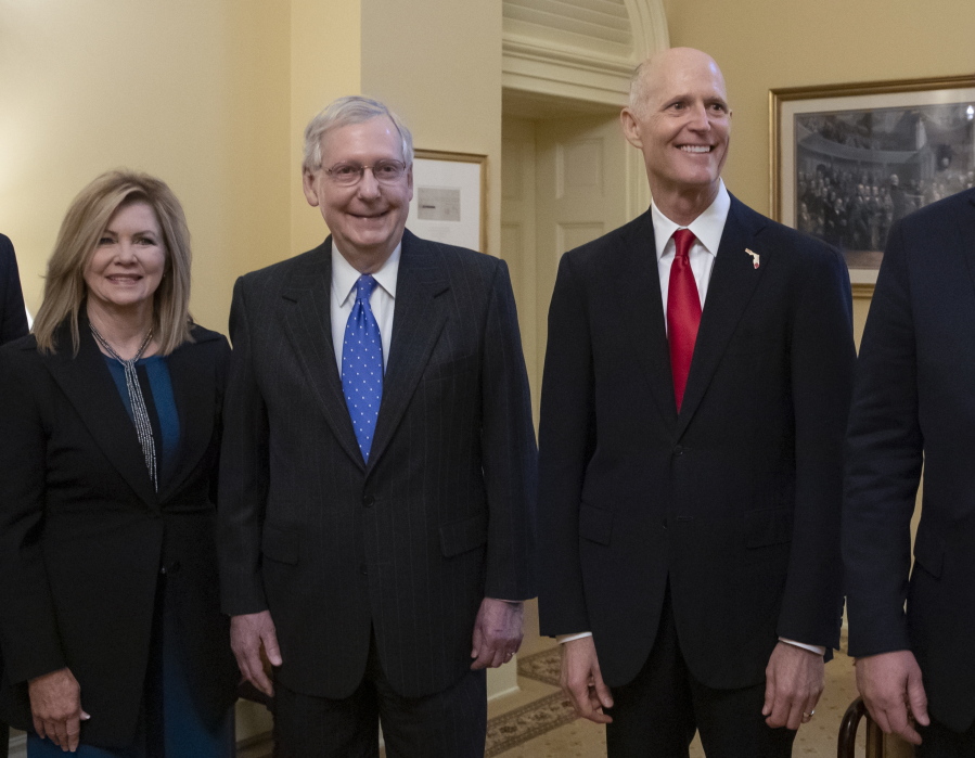 Senate Majority Leader Mitch McConnell, R-Ky., center, is flanked by Rep. Marsha Blackburn, R-Tenn., left, the senator-elect from Tennessee, and Florida Gov. Rick Scott, the Republican candidate in the undecided challenge to incumbent Sen. Bill Nelson, D-Fla., during a meeting with new GOP senators at the Capitol in Washington, Wednesday, Nov. 14, 2018. (AP Photo/J.