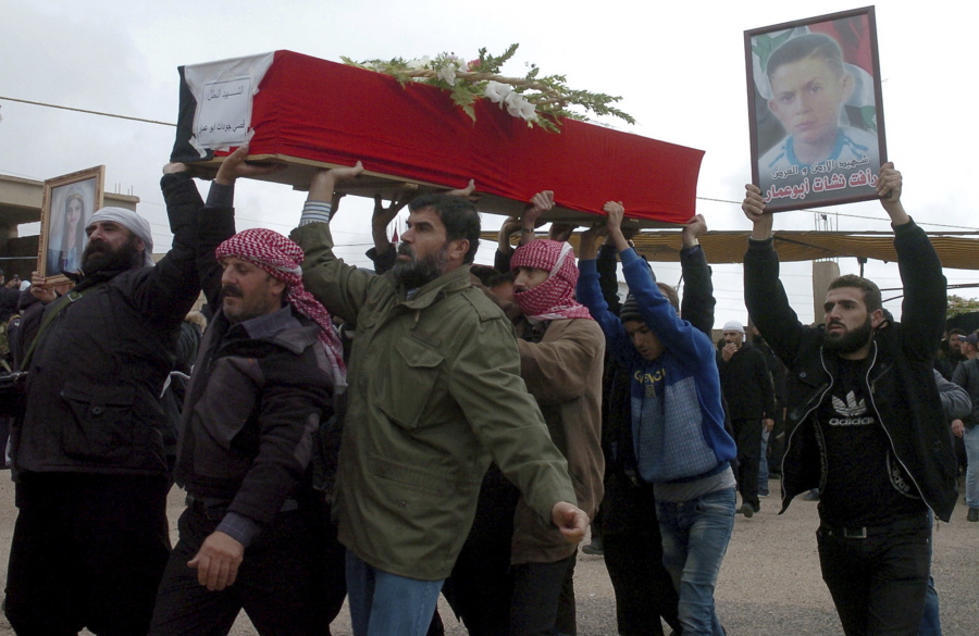 In this photo released by the Syrian official news agency SANA, mourners carry the coffin of Rafat Nashat during a mass funerals in Sweida province, Syria, Saturday, Nov. 10, 2018. Nashat was kidnapped by Islamic State militants with nearly two dozen others in July from the southern Sweida province during a bloody attack on their villages.