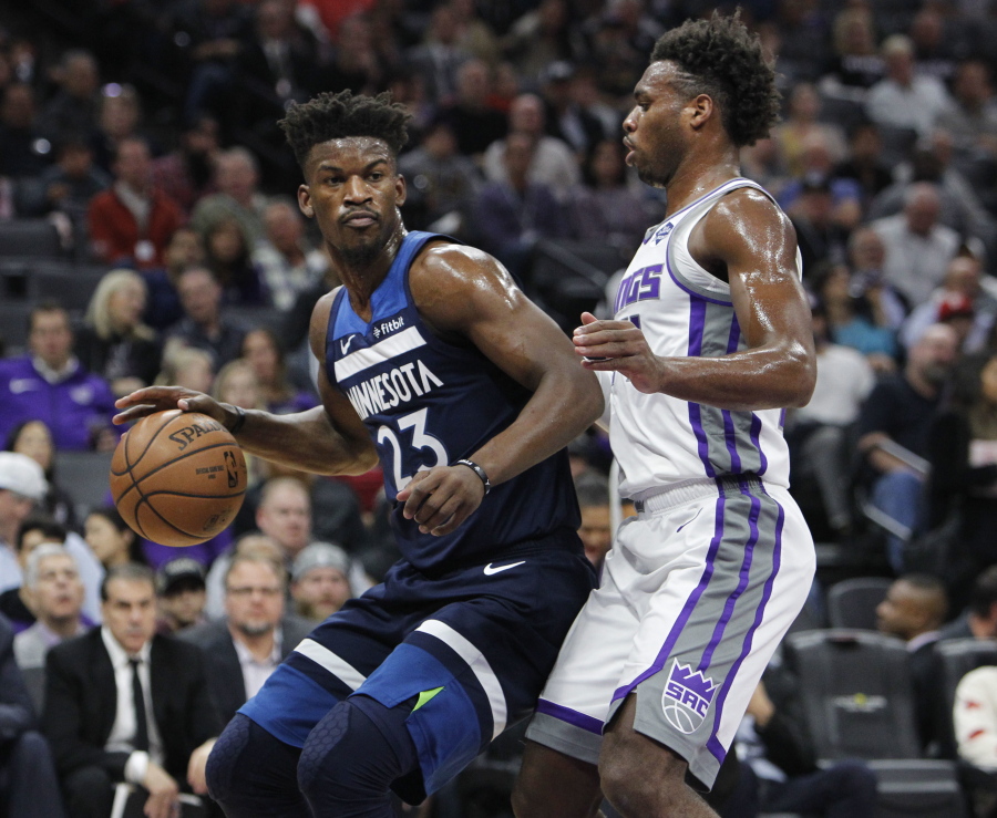 Minnesota Timberwolves guard Jimmy Butler (23) battles for position against Sacramento Kings guard Buddy Hield (24) during the first half of an NBA basketball game in Sacramento, Calif., Friday, Nov. 9, 2018.