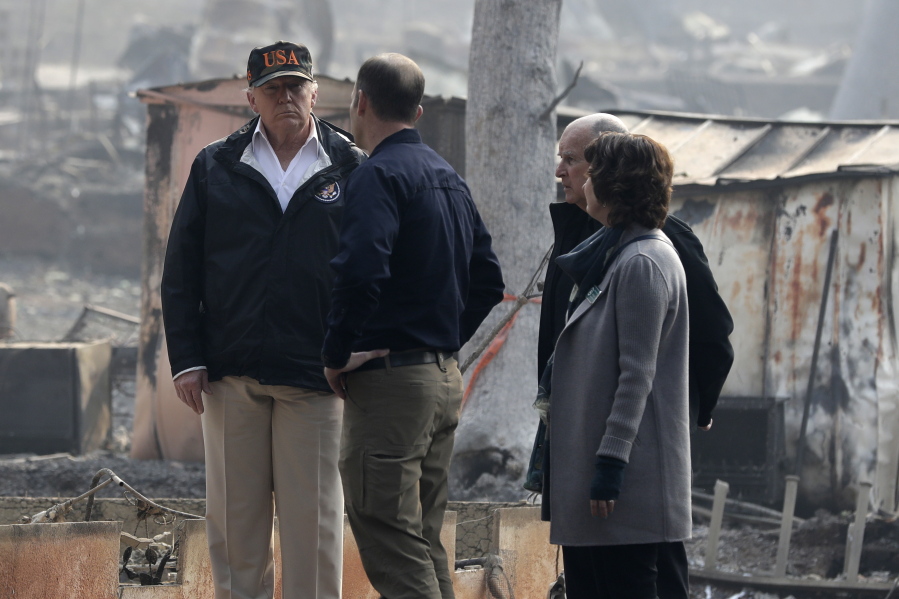 President Donald Trump talks with FEMA Administrator Brock Long, Jody Jones, Mayor of Paradise, and California Gov. Jerry Brown, second from right during a visit to a neighborhood impacted by the wildfires, Saturday, Nov. 17, 2018, in Paradise, Calif.
