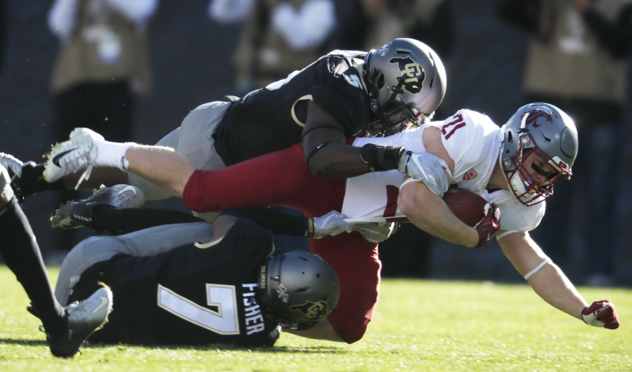 Washington State running back Max Borghi, center, is tackled after a short gain by Colorado linebacker Davion Taylor, top, and defensive back Nick Fisher in the first half of an NCAA college football game Saturday, Nov. 10, 2018, in Boulder, Colo.