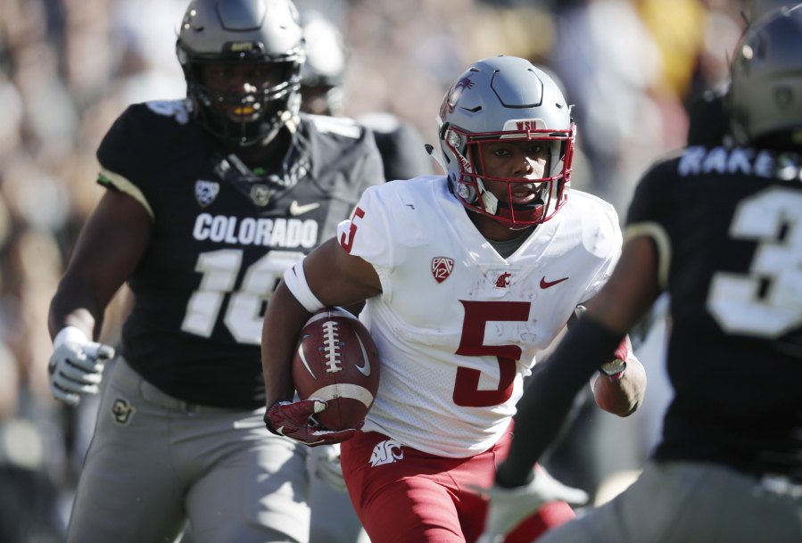 Washington State wide receiver Travell Harris, center, runs for a long gain past Colorado linebacker Alex Tchangam, back, and toward defensive back Derrion Rakestraw in the first half of an NCAA college football game Saturday, Nov. 10, 2018, in Boulder, Colo.