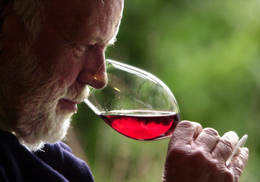 Winemaker David Lett savors the bouquet from a glass of pinot noir at his Eyrie Vinyards home in Dundee, Ore. Officials in Oregon and at a U.S. government agency are similarly finicky, and have told a California winery to back off its claims it makes an Oregon pinot noir.