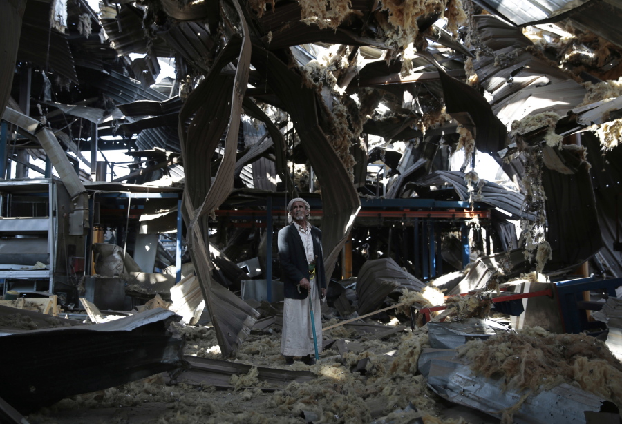 In this Sept. 22, 2016, file photo, a man stands among the rubble of the Alsonidar Group’s water pump and pipe factory after it was hit by Saudi-led airstrikes in Sanaa, Yemen. The Saudi-led coalition fighting in Yemen said early Saturday, Nov. 10, 2018, it had “requested cessation of inflight refueling” by the U.S. for its fighter jets after American officials said they would stop the operations amid growing anger over civilian casualties from the kingdom’s airstrikes.