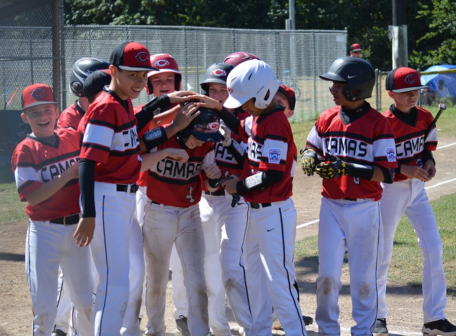 (Files/The Columbian) Jackson Knuth gets patted down by his teammates at home plate after hitting a 3-run home run for the Camas Little League Major all-star baseball team last summer at David Douglas Park in Vancouver.