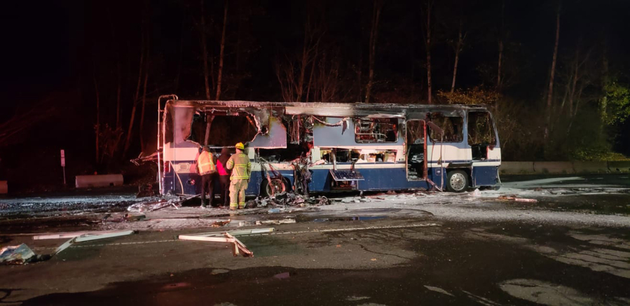 Firefighters inspect the remains of a motor home destroyed in a fire Tuesday night at the southbound Gee Creek rest area off Interstate 5.