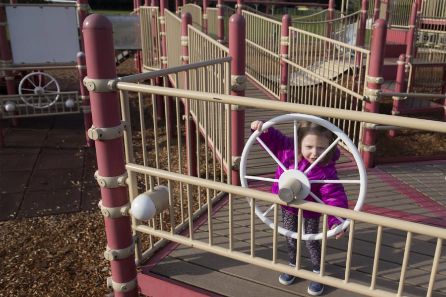 Lucy Flora, 2, turns a steering wheel on the Felida Community Park playground. With its raised platforms and wood chip surfacing, the playground is not accessible to children of all abilities. However, in 2019 or 2020 the county will construct the first all-abilities play area in this park.