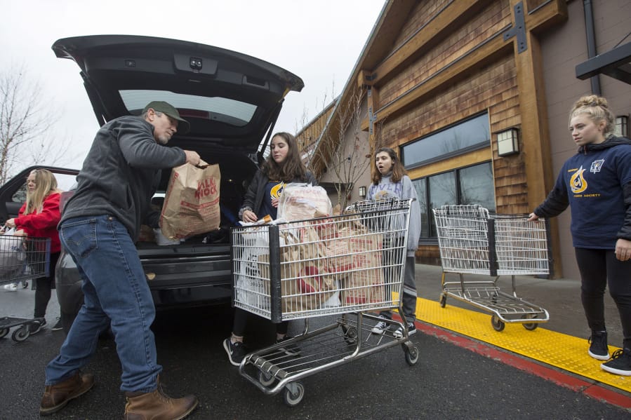 Volunteers unload food donations at the Chuck’s Produce collection site during the annual Walk & Knock charity food drive.