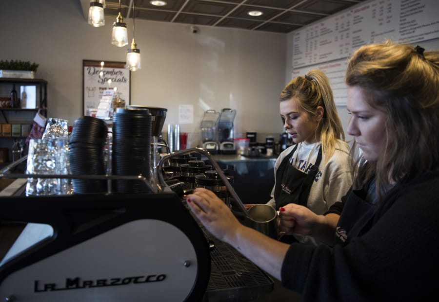 Brittany Tese, left, and Karlee Hofman, right, both of Vancouver, make coffee at Red Barn located in the Erickson Farms retail area. Red Barn opened earlier this year in the new retail area.