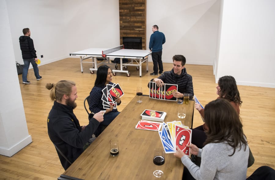 CoLab members play Jumbo Uno during a weekly CoLab happy hour in their new event space, Tandem Hall, behind Boomerang Coffee in downtown Vancouver.
