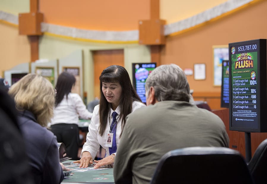 Dealer Sandy Pham looks over cards while assisting players at The Last Frontier Casino. The casino has about 200 employees.