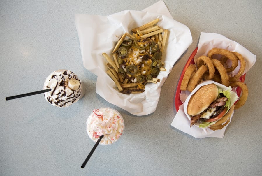The chili cheese fries, top center, the Bacon and Bleu Cheeseburger and onion rings, right, the Candy Cane Shake, bottom, and the Tropical Monkey Shake, left, are seen at K&M Drive-In in Camas.