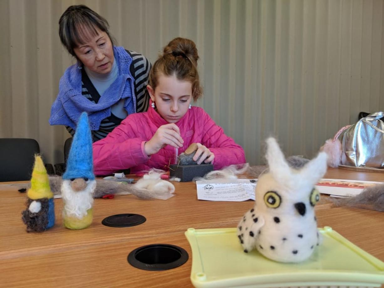 Needle-felting instructor Juneko Martinson assists a pupil with her three-dimensional wool raccoon during Martinson’s workshop Nov. 17 at the Fort Vancouver Visitor Center. Martinson’s felted creatures are in the foreground. Martinson also planned to teach a workshop Saturday to make a needle-felted gnome.