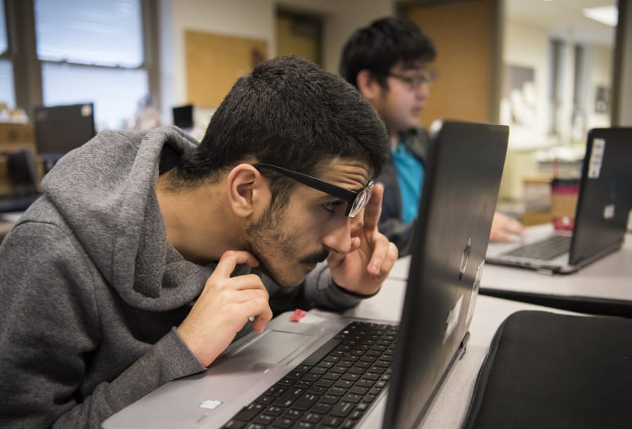 Washington State School for the Blind sophomore Dima Faraj, left, and senior Angel Patino, center, work on a lesson during the computer science principles class at Washington School for the Blind in Vancouver.