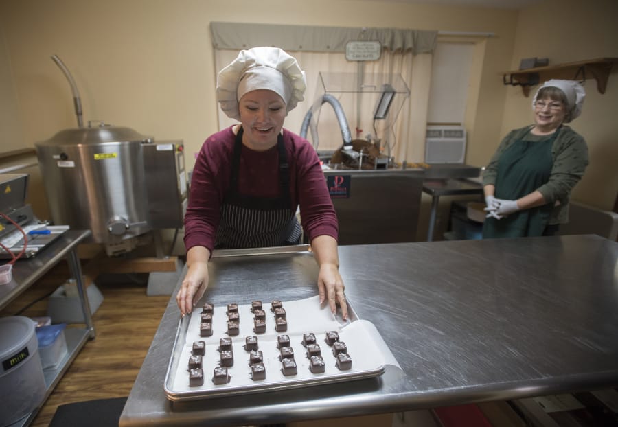 Pamela Wanous, left, and Ann Wanous, co-owners of Whimsy Chocolates, prepare a batch of salted caramels in Whimsy’s kitchen in Battle Ground.
