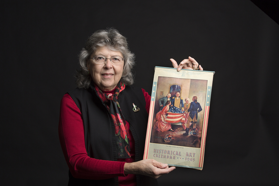Calendar collector Cyrilla Gleason holds a historical art calendar from 1945. Its days are compatible with the 2018 calendar.
