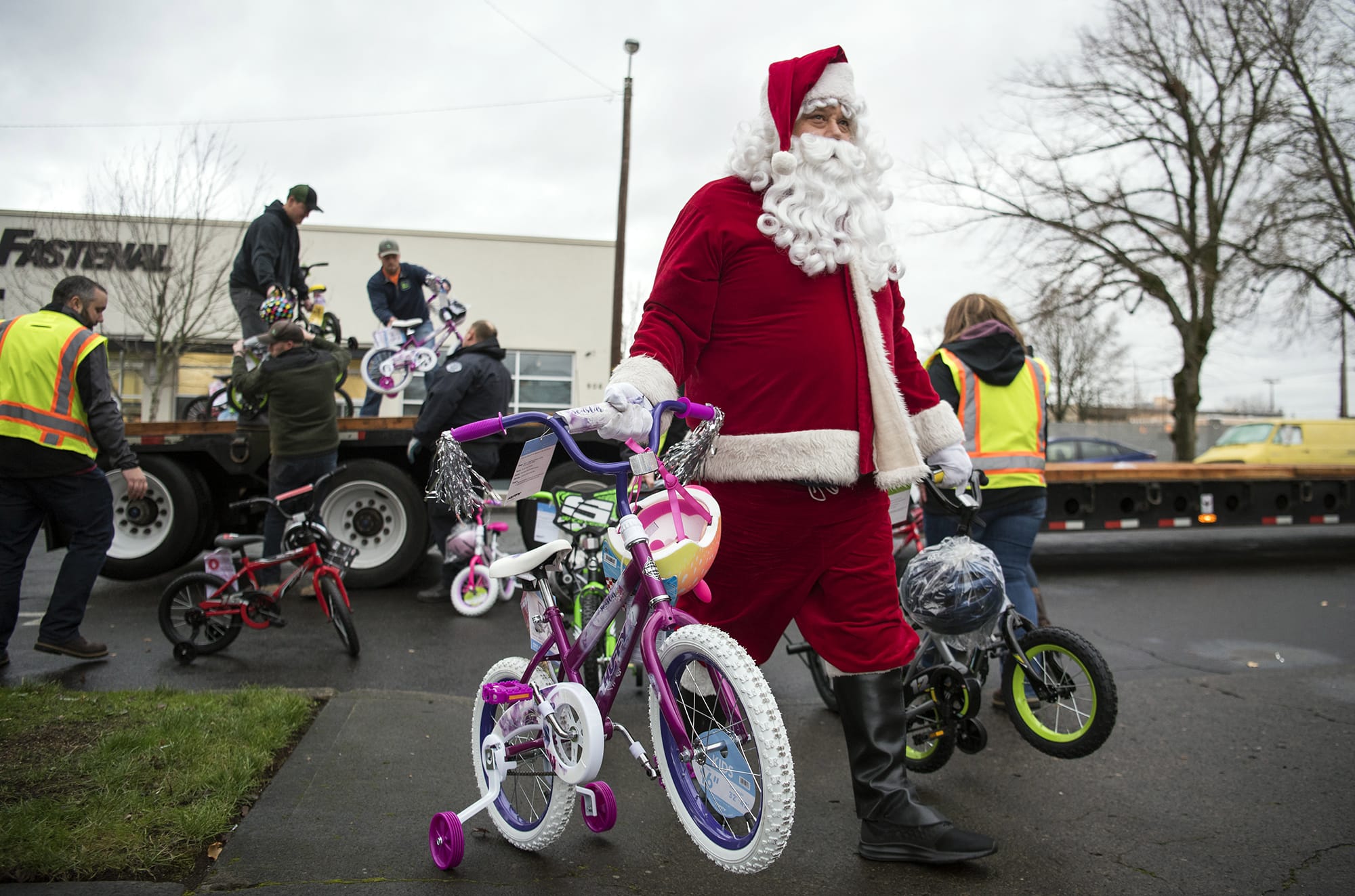 Doug Morris, with Waste Connections, helps unload a truck of 200 bikes for the annual Scott Campbell Christmas Promise at Washington Department of Social and Health Services in Vancouver on Tuesday.