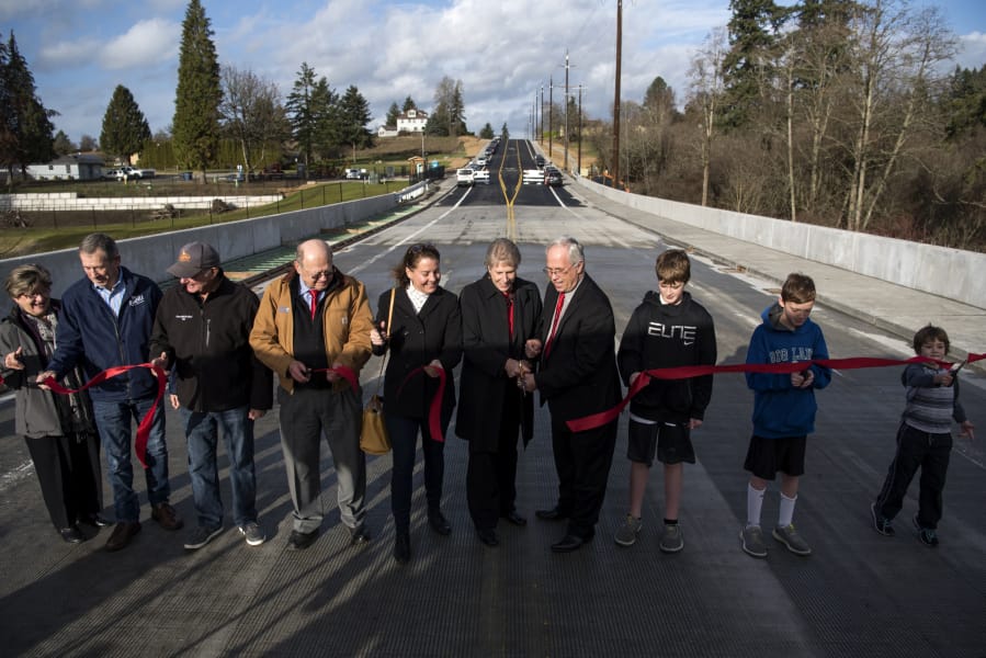 Local officials and community members gather Tuesday for a ribbon cutting to celebrate the opening of the new bridge that will carry traffic on Northeast 10th Avenue over Whipple Creek south of the fairgrounds.