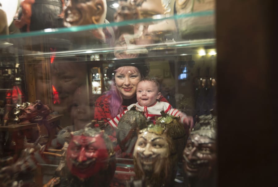 Museum guest Carmel Rosa, with son Owen Thorn, look at artifacts on display at the Devil-ish Little Things Museum in Rose Village on Sunday afternoon.