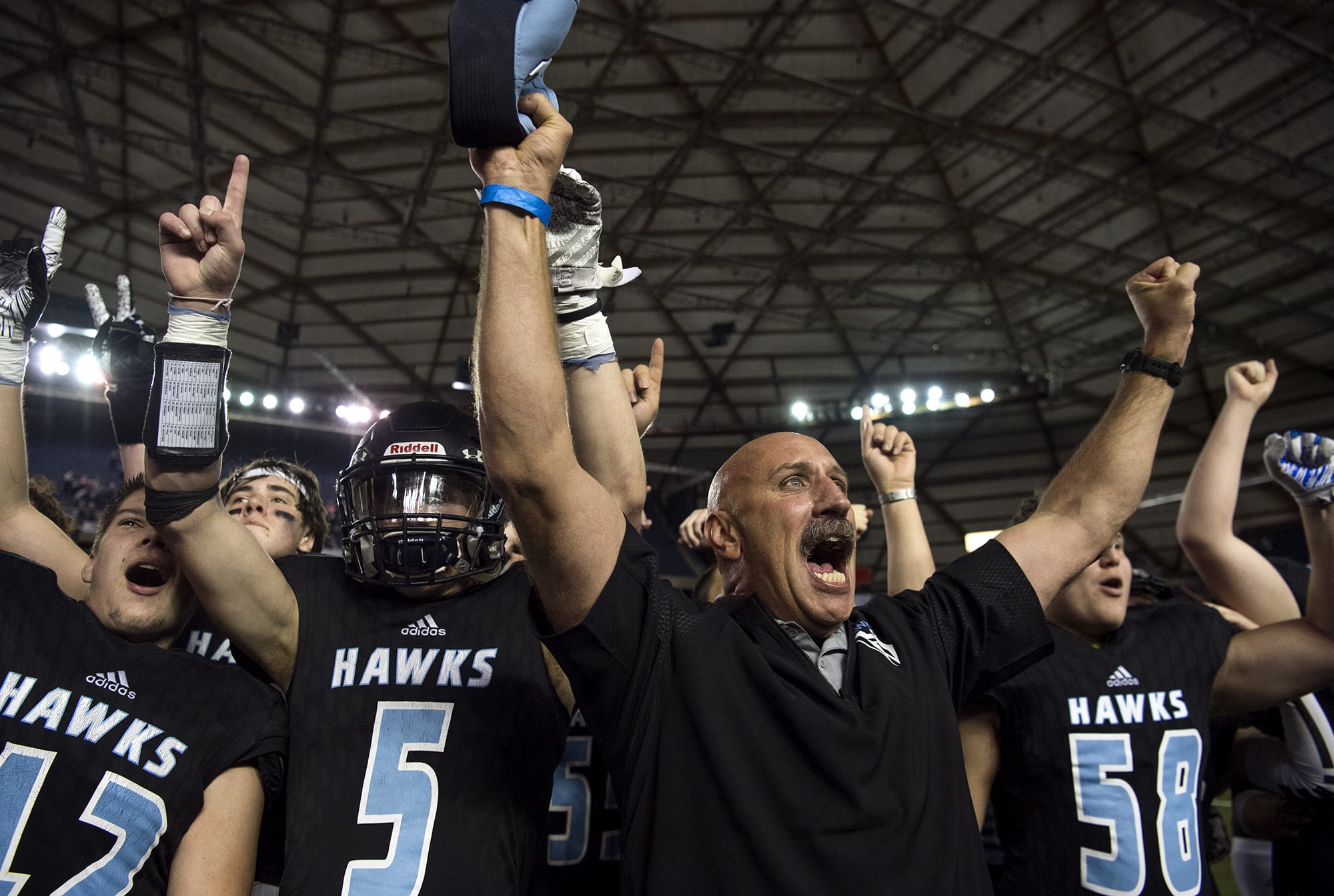Hockinson coach Rick Steele and his team celebrate after winning their second straight 2A state football championship game on Saturday, Dec. 1, 2018, in Tacoma, Wash. Hockinson defeated Lynden 42-37.